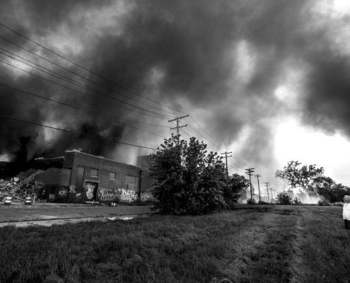 A couple watches a multi-alarm commercial building fire in the west side of Detroit. Lieutenant Gerard Funderberg of the Detroit Fire Department declared the fire a Hazmat Level 3 situation. As a precautionary measure, the Lieutenant asked the residents that live close by to keep their windows and doors closed.