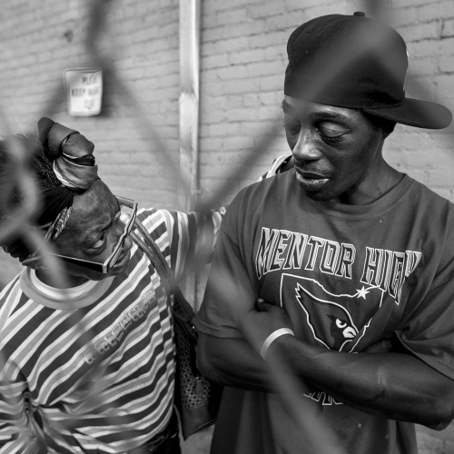 A woman tries to convince a heavily intoxicated man who was standing outside the Neighborhood Service Organization (NSO) to go inside and sober up. .